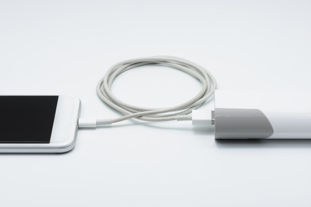 Closeup of White smart phone charger with power bank (battery bank) on white backgroundの写真素材