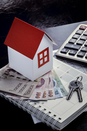 Single family house on pile of money. Concept of real estate.の写真素材