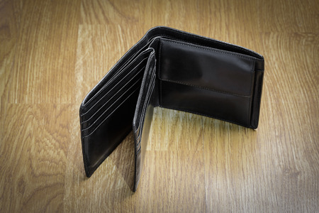 Closeup Of Minimalist Plain Black Modern Money Wallet For Male Placed on Wood Table Background