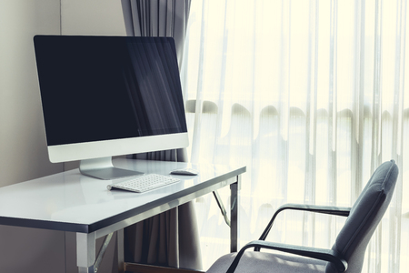 Blank computer desktop with keyboard, diary and other accesories on white table in morningの写真素材