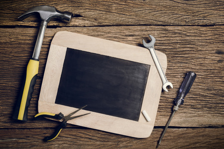 slate board and Hand Tool on wooden backgroundの写真素材
