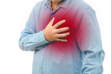 Young man with strong chest pain on white backgroundの写真素材