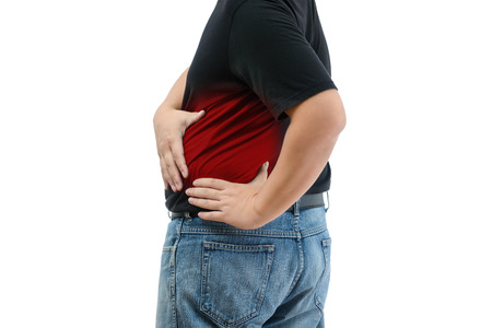 Young man suffering from strong backache on white backgroundの写真素材