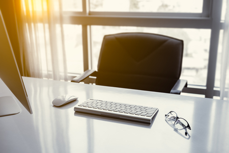 Manager Table with Desktop Computer and eye glasses Inside the Officeの写真素材