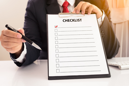 Midsection of businessman holding clipboard with checklist againstの写真素材