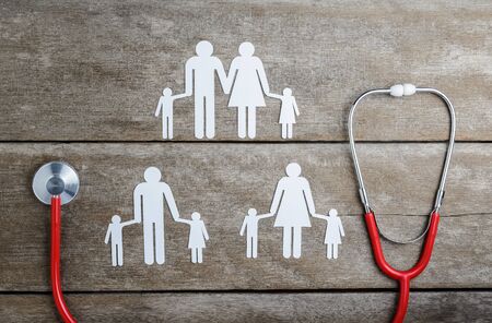 Red heart, stethoscope and paper chain family on wooden table, Health Insurance Conceptsの写真素材
