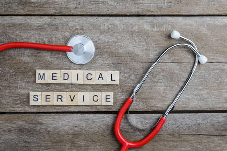 Medical Service text word made with wood blocks and Red Heart,stethoscope on wooden table, health background concepts.の写真素材