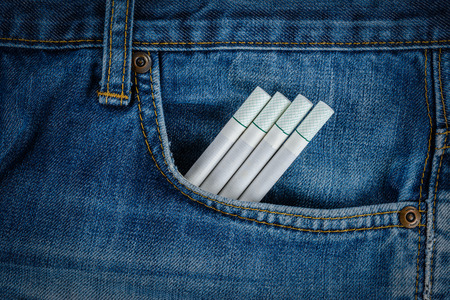 Close up view of Cigarettes in old blue denim jeans pocketの写真素材