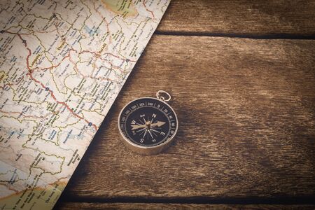 Compass and map on wooden table and space on wood