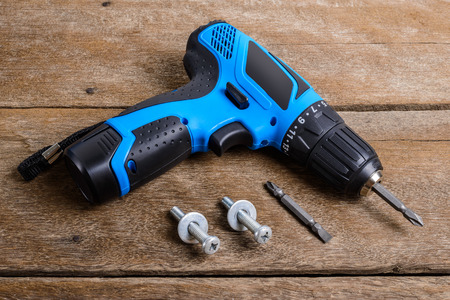 Close up Electric screwdriver, Screwdriver set, adapter on wooden table background and copy space. Hammer drill or screwdriver, Electric cordless hand drill on wooden.  maintenance home concept.の写真素材