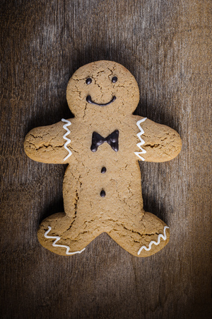 Gingerbread man Christmas and New Year cookie icon on wooden table background