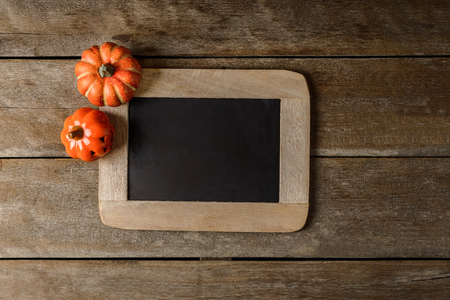Halloween pumpkin head jack lantern with Chalk board on grunge wooden background. Top viewの写真素材