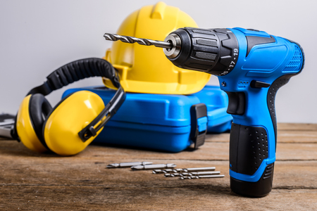 Drill and set of drill,tools,carpenter and safety, Protection Equipment on wooden table backgroundの写真素材