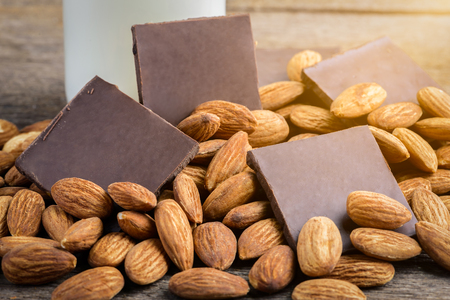 milk in bottle, chocolate and almond on wooden backgroundの写真素材