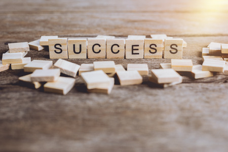 Words SUCCESS made with block wooden letters. Wood abc. on wooden table
