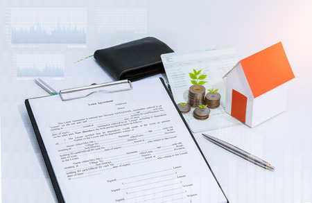 saving account passbook or financial statement, paper house model, Little tree and coins with Property Leasing Agreement on office desk table. Business, finance, property ladder or mortgage loan conceptの写真素材