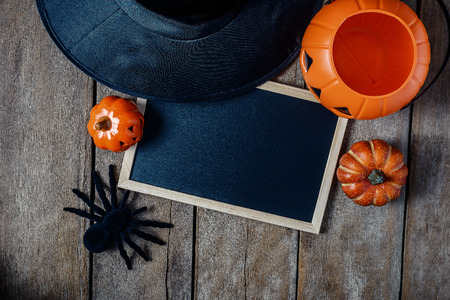 halloween background with Pumpkins, Witch hat, Black spider and empty chalkboard on wooden floor. view from aboveの写真素材