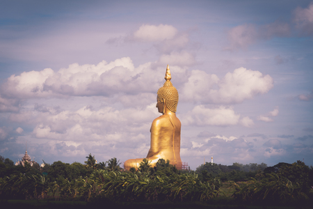 Scenery of Rice field and Big Golden Buddha statue at Wat Muang Temple landmark of angthong province, Thailandの写真素材