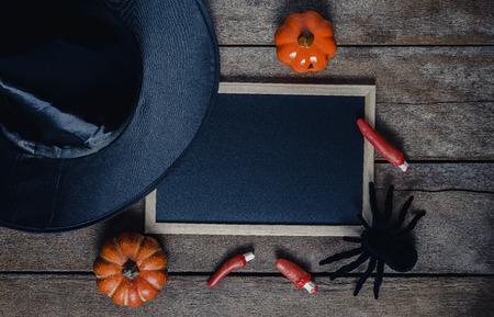 halloween background with Pumpkins, Witch hat, Black spider and empty chalkboard on wooden floor. view from aboveの写真素材