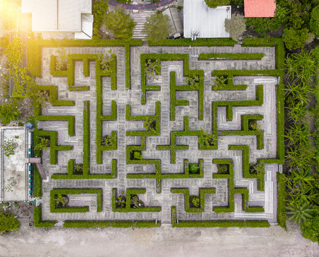 Aerial view of Garden Decoration is a maze with Green leaves wall fence with concrete bush or shrub trimming. Top viewの写真素材