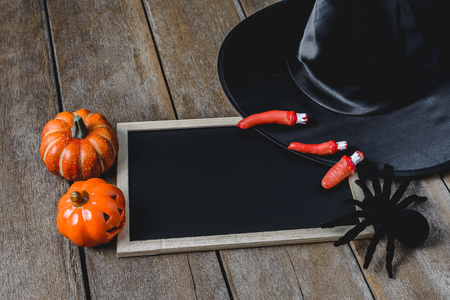 halloween background with Pumpkins, Witch hat, Black spider and empty chalkboard on wooden floor. view from aboveの写真素材