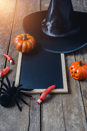 halloween background with Pumpkins, Witch hat, Black spider and empty chalkboard on wooden floor. view from aboveの写真素材
