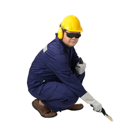 worker in Mechanic Jumpsuit Sitting and holding a paint brush with helmet, earmuffs, Protective gloves and Safety goggles isolated on white background clipping pathの写真素材