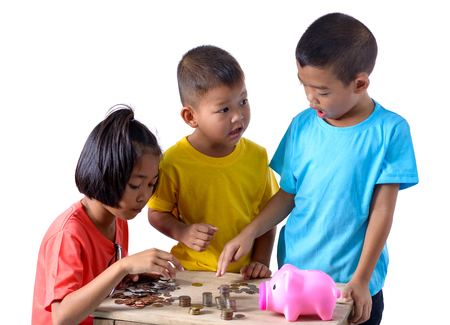 Group of asian children are helping putting coins into piggy bank isolated on white background  . Education Savings conceptsの写真素材