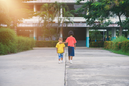 background of Back view Little asian Brothers and sisters walk hand in hand. love family conceptsの写真素材