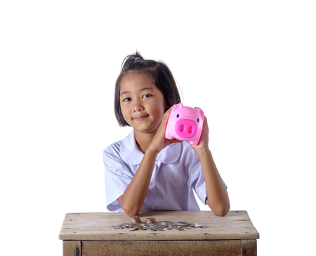 Cute asian girl in school uniform have fun with piggy bank and coins isolated on white background . Education Savings conceptsの写真素材