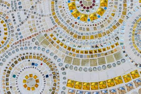 Close up Background of handwork on fancy white and gold ceramic decorated the wall of buddhism pagoda in Wat Pha Son Kaew, Petchaboon Thailandの写真素材