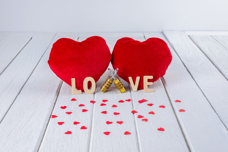 Valentines Day background with Red Heart shape, Wooden letters word "LOVE" and Couple Combination golden padlock on white wooden table and copy space for your graphic.の写真素材