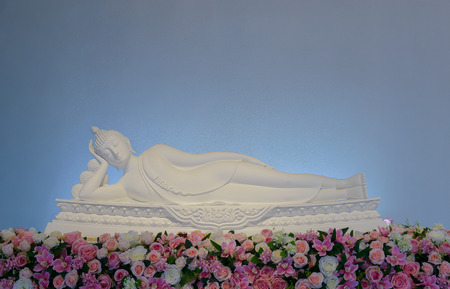 White Buddha statue lying on stand Decorated with beautiful flowersの写真素材