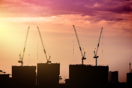 Silhouette background of Construction site with cranes against the background of the morning skyの写真素材