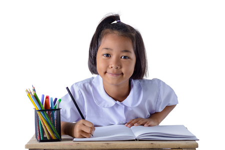 portrait of asian girl in school uniform is drawing with color pencils isolated on white background with clipping pathの写真素材