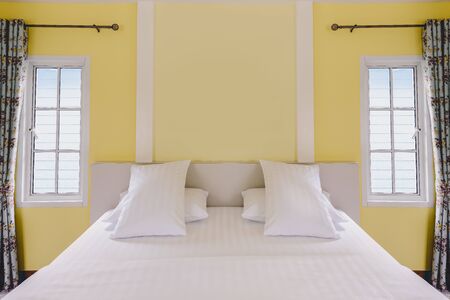 Modern yellow bedroom interior and white bedding in vintage houseの写真素材