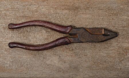 old pliers on wooden rustic grunge backgroundの写真素材