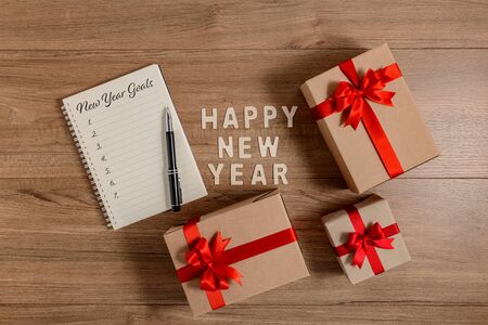 HAPPY NEW YEAR 2020 Wood New Year's Goals List written on Notebook with gift box on wooden backgroundの写真素材
