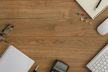 Flat lay, top view wooden office desk. Workspace with blank notebook, keyboard, mouse computer,...
