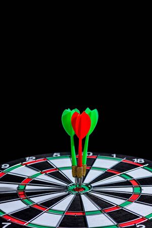 Red and green dart arrow hitting target center Dart board Isolated on black background, Setting aim goal achievement concept challenging business goals And ready to achieve goal and Marketing conceptの写真素材