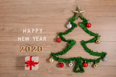 Creative winter layout made with evergreen tree branches and ornament, gift boxes on wooden background. Flat lay Christmas trees and New Year 2020  concepts. Top view and copy spaceの写真素材