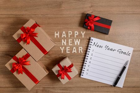 HAPPY NEW YEAR 2020 Wood New Year's Goals List written on Notebook with gift box on wooden backgroundの写真素材