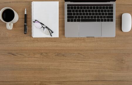 Flat lay, top view wooden office desk. Workspace with blank clipboard, laptop, mouse computer, pen,...