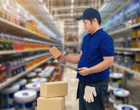 Male staff Delivering products Sign the signature on the product receipt form with parcel boxes Blurred the background of the warehouseの写真素材