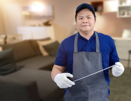 Craftsman home renovation working with Measuring Tape and blurred background of living roomの写真素材
