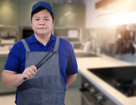 Male Chef assistant holding Kitchen equipment tools and blurred background kitchenの写真素材