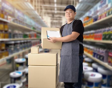 Male staff Delivering products Sign the signature on the product receipt form with parcel boxes Blurred the background of the warehouseの写真素材