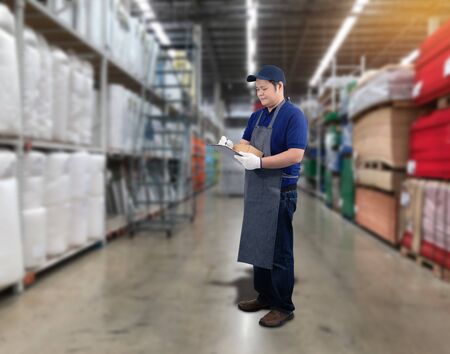 Male staff Delivering products Sign the signature on the product receipt form with parcel boxes Blurred the background of the warehouseの写真素材