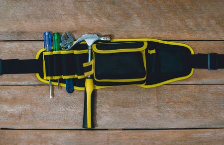 Top view of tool belt bag and old instruments constructor or renovation for build and repair house on rustic grunge wooden backgroundの写真素材
