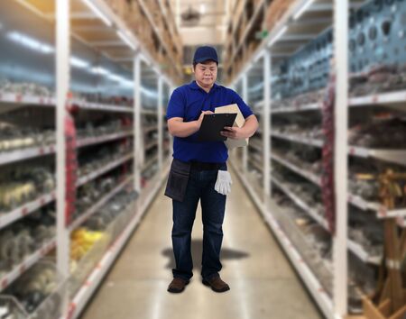 Male staff Delivering products Sign the signature on the product receipt form with parcel boxes Blurred the background of the warehouseの写真素材
